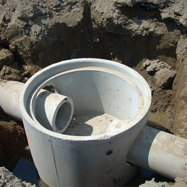 Precast concrete part of a manhole lowered into the ground.