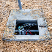 Concrete utility vault with access panel opened.